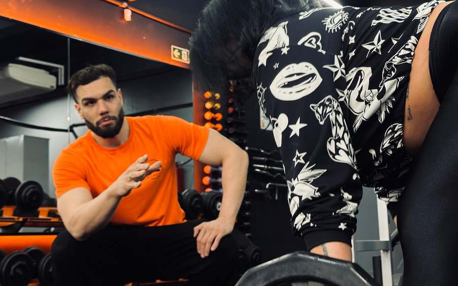 Professor da Be Fitness acompanhando o levantamento de uma aluna
